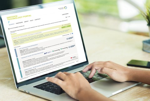 In the photo you can see the hands of a person on a laptop keyboard. The person is searching in the DRESDEN Technology Portal.
