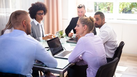 Gruppe von Geschäftsleuten, die während des Geschäftstreffens im Büro sitzen.
