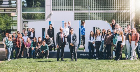 Professor Schoop mit internationale Gästen vor der TU Dresden Plastik am HSZ.