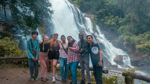 Group picture of international students in front of a waterfall.