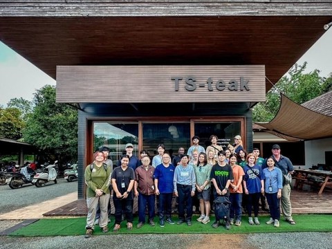 Gruppenbild vor einem hölzernen Gebäude mit dem Schriftzug "TS-teak".