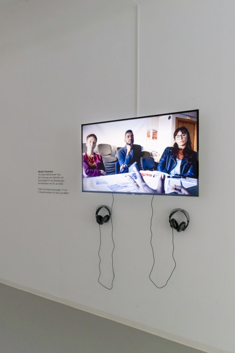 Bildschirm mit Kopfhörern in der Ausstellung "Gefährliche Grenze".