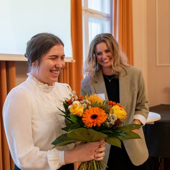 Preisträgerin erhält Blumen