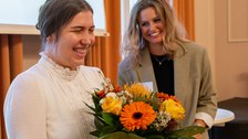 Preisträgerin erhält Blumen