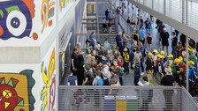 In einem Treppenhaus stehen viele Kinder vor einer Tür.
