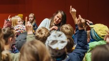 Nach der Vorlesung stehen einige Kinder bei der Referentin und stellen ihr Fragen. Dazu melden sie sich mit Handzeichen.