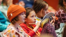 Die Kinder hören aufmerksam zu und machen sich Notizen.
