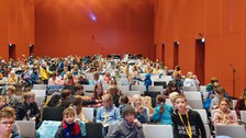 Ein Blick in den Saal. Viele Kinder sitzen schon in den Sitzreihen.