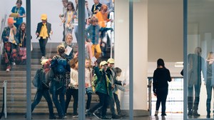 Das Foto zeigt Kinder, die im Hygiene-Museum nach der Vorlesung die Treppe runtergehen. Ein Junge winkt in Richtung Kamera. 