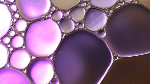 zu sehen ist Oel, dass violett gefärbt ist, wie es auf Wasser schwimmt