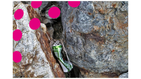 Zu sehen ist eine zerquetschte Dose, wie sie zwischen zwei Felsen liegt. 