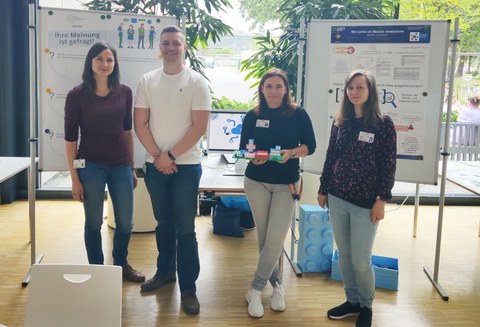 4 Personen vor 2 Posterleinwänden
