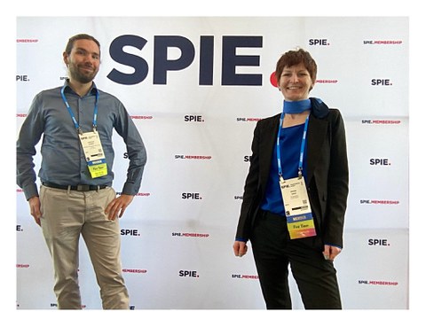 Das Foto zeigt zwei Personen vor dem Logo der SPIE.