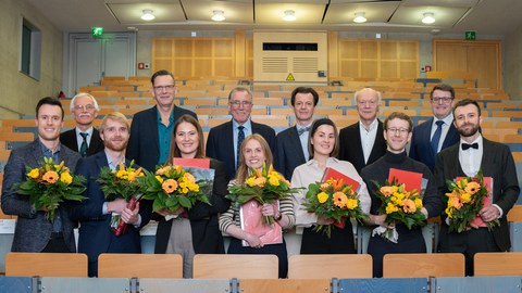 Preisträgerinnen und Preisträger gemeinsam mit den Laudatoren bei einem Gruppnbild im Hörsaal