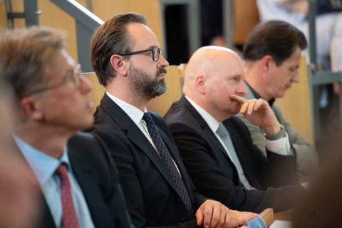 Wissenschaftsminister Sebastian Gemkow hört einem Vortrag zwischen zwischen Prof. Uwe Platzbecker und Martin Peuker zu