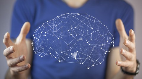 Der Oberkörper einer Person, die mit ihren Händen ein Hologramm eines Gehirnes präsentiert.