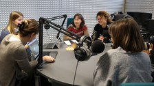 Personen an einem Podcast-Tisch