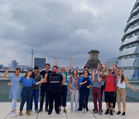 Gruppe von Leuten mit Fernsehturm im Hintergrund