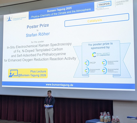 Mann vor Präsentation mit Posterpreis