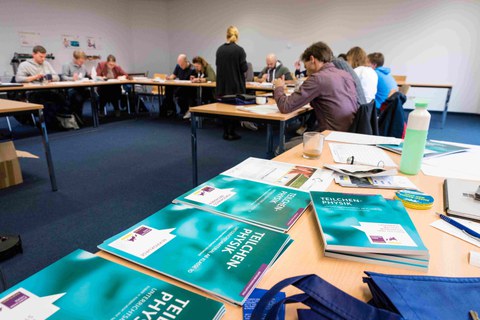 Mehrere Personen sitzen in einem Seminarraum