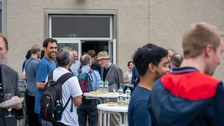 Auf der Dachterrasse des Recknagel-Baus stehen Menschen bei einem Empfang.