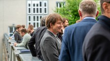 Auf der Dachterrasse des Recknagel-Baus stehen Menschen bei einem Empfang.