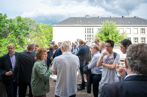 Auf der Dachterrasse des Recknagel-Baus stehen Menschen bei einem Empfang.