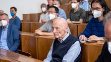 In einem Hörsaal sitzen mehrere Personen. Ganz vorne sitzt Professor Peter Fulde.
