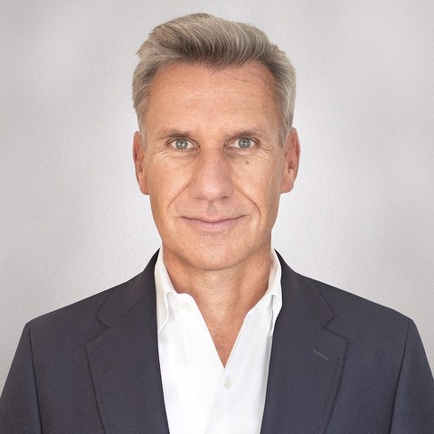 Portraitaufnahme von Prof. Markus Scholz, ein weißer Mann mittleren Alters, der einen Dunklen Anzug trägt