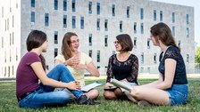 Vier Frauen lernen auf einer Wiese vor der Sächsischen Landes- und Universitätsbibliothek.