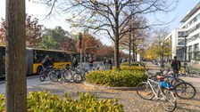 Foto vom belebten Platz vor dem DrePunct im Herbst mit vielen Fahrrädern und einem Bus der DVB.