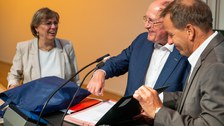 Redner unterschreibt in einem Buch 