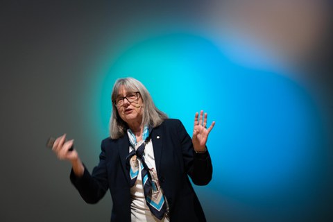 Donna Strickland bei ihrem Vortrag. Im Hintergrund bunte Beleuchtung.