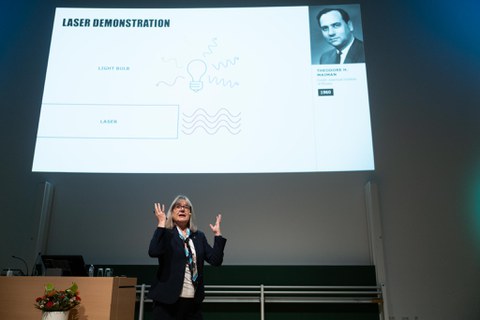 Donna Strickland steht im Hörsaal, im Hintergrund die Präsentation.