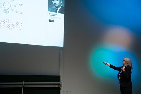 Donna Strickland zeigt mit der Hand auf ihre Präsentation.