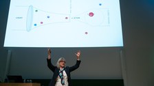 Donna Strickland erklärt mit beiden Händen nach oben gerichtet.