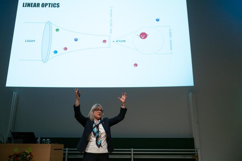 Donna Strickland erklärt mit beiden Händen nach oben gerichtet.