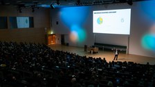 Blick in den Hörsaal, der bunt beleuchtet ist.
