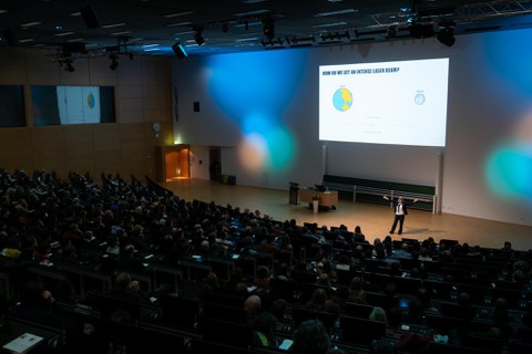 Blick in den Hörsaal, der bunt beleuchtet ist.