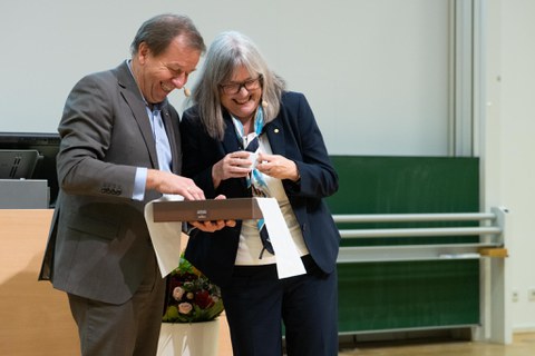 Donna Strickland und Clemens Kirschbaum schauen in eine Box. 