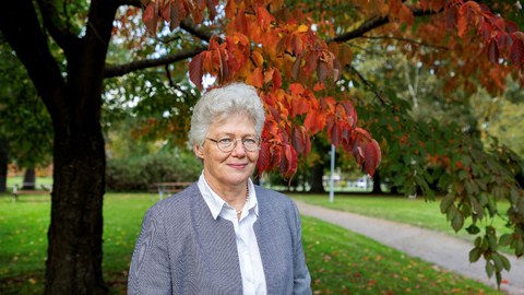Prof. Anne L'Huillier steht vor einem Baum.