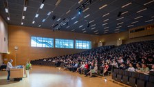 Prof. Dr. Angela Rösen-Wolff steht am Pult vorm vollen Audimax