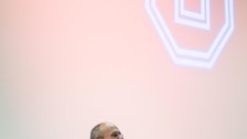 Prof. Dr. Carsten Timm vor dem Werbestand der Sponsoren "VON ARDENNE" Im Hintergrund wird das TU Logo mit einem Scheinwerfer an die Wand projizieren