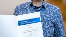 Dr. Lukas Körber mit der Urkunde zum Promotionspreis Physik.