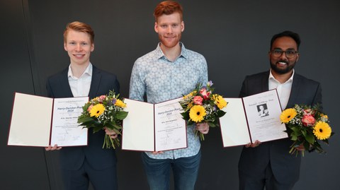 Die drei Preisträger mit einer Urkunde in der Hand.