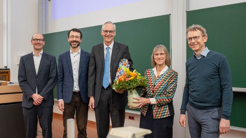Gruppenbild mit Blumenstrauß und Geschenk