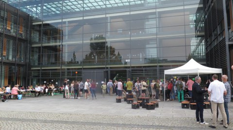 Vor dem Biologie Gebäude der TUD stehen Bänke und ein Zelt. Überall sind Menschen verteilt