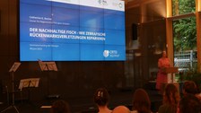 Eine Frau hält einen Vortrag mit dem Titel: "Der Nachhaltige Fisch- wie Zebrafische Rückenmarkverletzungen reparieren"