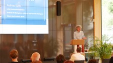Andreas Kurth steht auf der Bühne und hält einen Vortrag