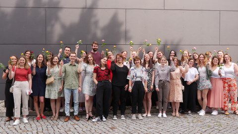 Gruppenbild, alle halten eine Rose hoch